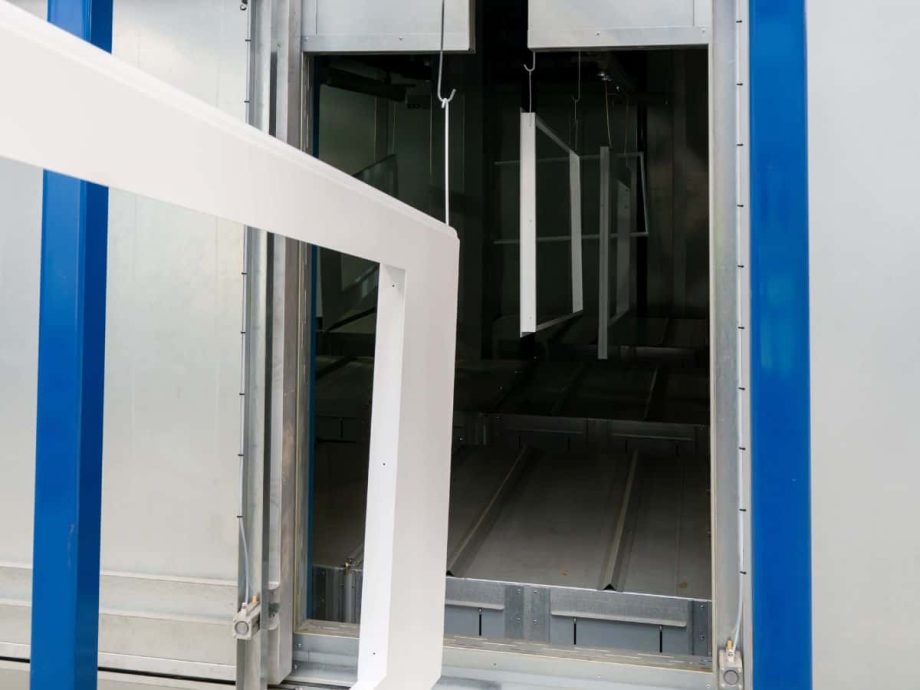 Metal components on conveyor entering powder coating process