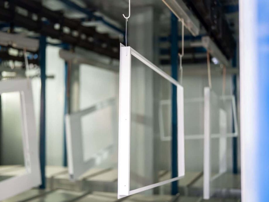 Sheet metal frames hanging on conveyor in powder coating line UK